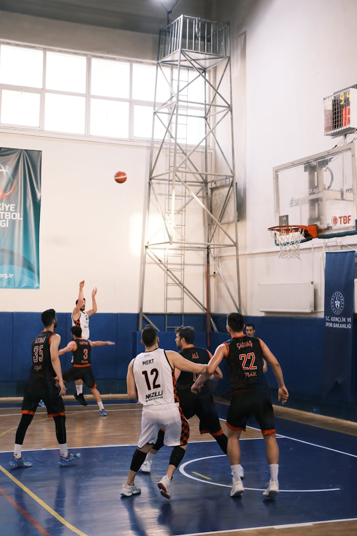 Players in mid-action on a basketball court in Nazilli. Competitive sports captured indoors.