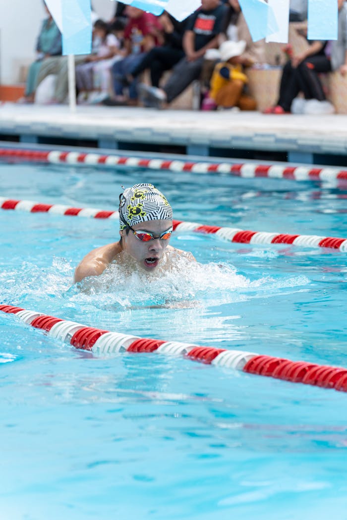 Swimmer in Puno, Peru, wearing a swim cap and goggles, competing in a pool race.